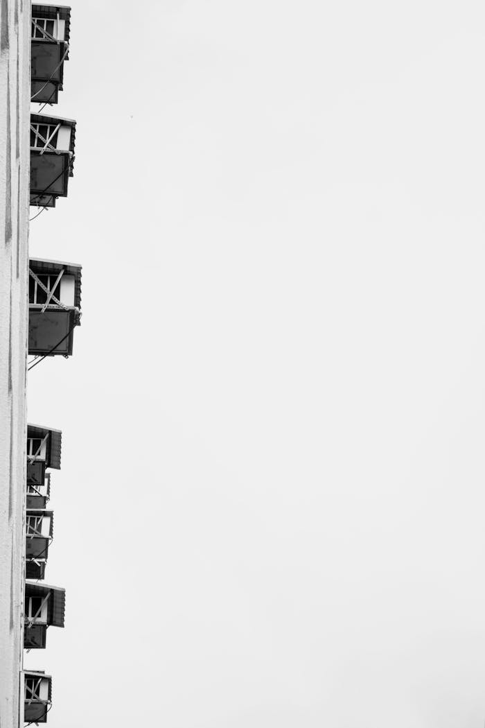 Black and white image of a building facade with air conditioning units, showcasing minimalism and urban architecture.
