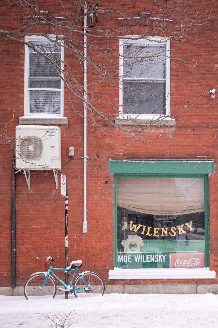 Classic storefront with bike and snow on a Montreal street in winter.